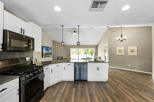 a kitchen with a sink stove top oven and cabinets