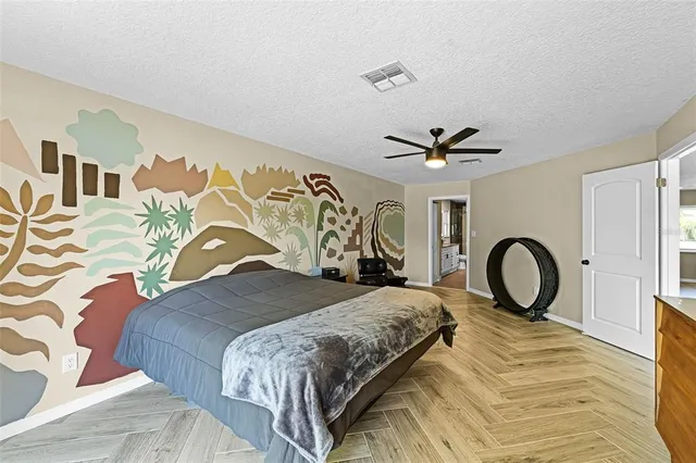 a bedroom with a bed and a large mirror on the dresser