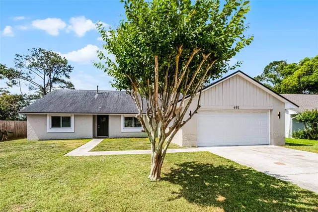 a white house that has a tree in front of it