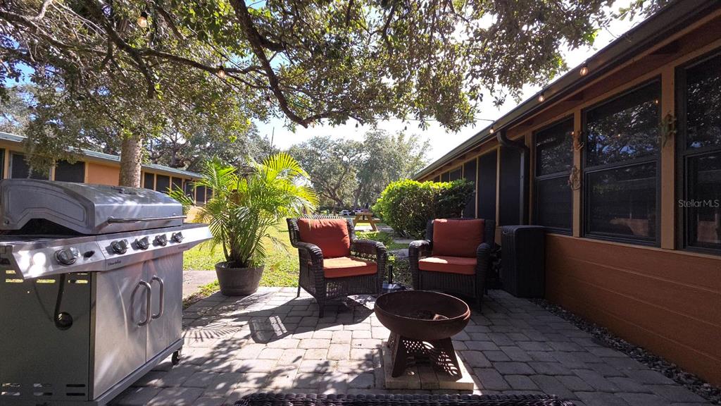 3200 River Ranch Boulevard, Unit 303 River Ranch, FL 33867 - Photo 14 of 16 a view of a patio with table and chairs potted plants and a large tree