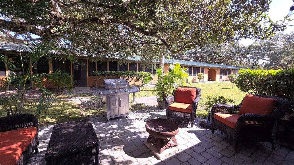 3200 River Ranch Boulevard, Unit 303 River Ranch, FL 33867 - Photo 15 of 16 a view of a patio with table and chairs potted plants and large tree