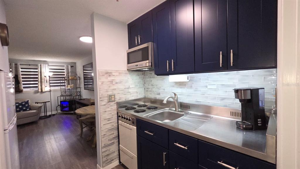 3200 River Ranch Boulevard, Unit 303 River Ranch, FL 33867 - Photo 4 of 16 a kitchen with a sink cabinets and wooden floor