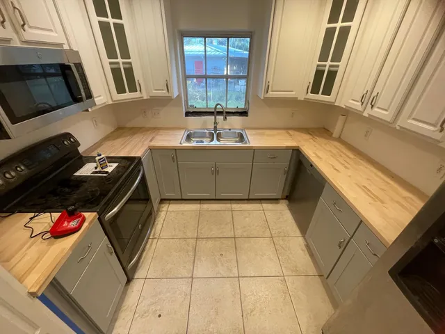 a kitchen with stainless steel appliances granite countertop a sink stove and microwave