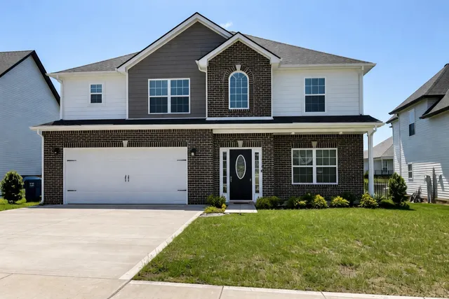 a front view of a house with a garden and plants