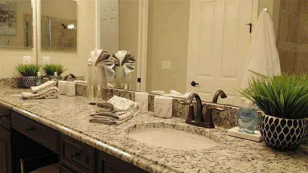 a bathroom with a granite countertop sink toilet and shower