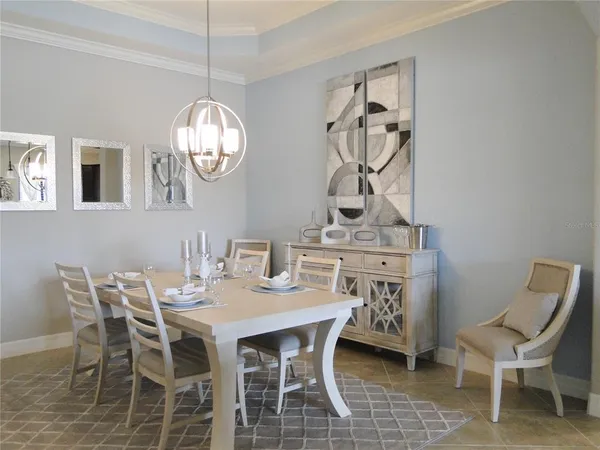 a dining room with furniture a chandelier and wooden floor