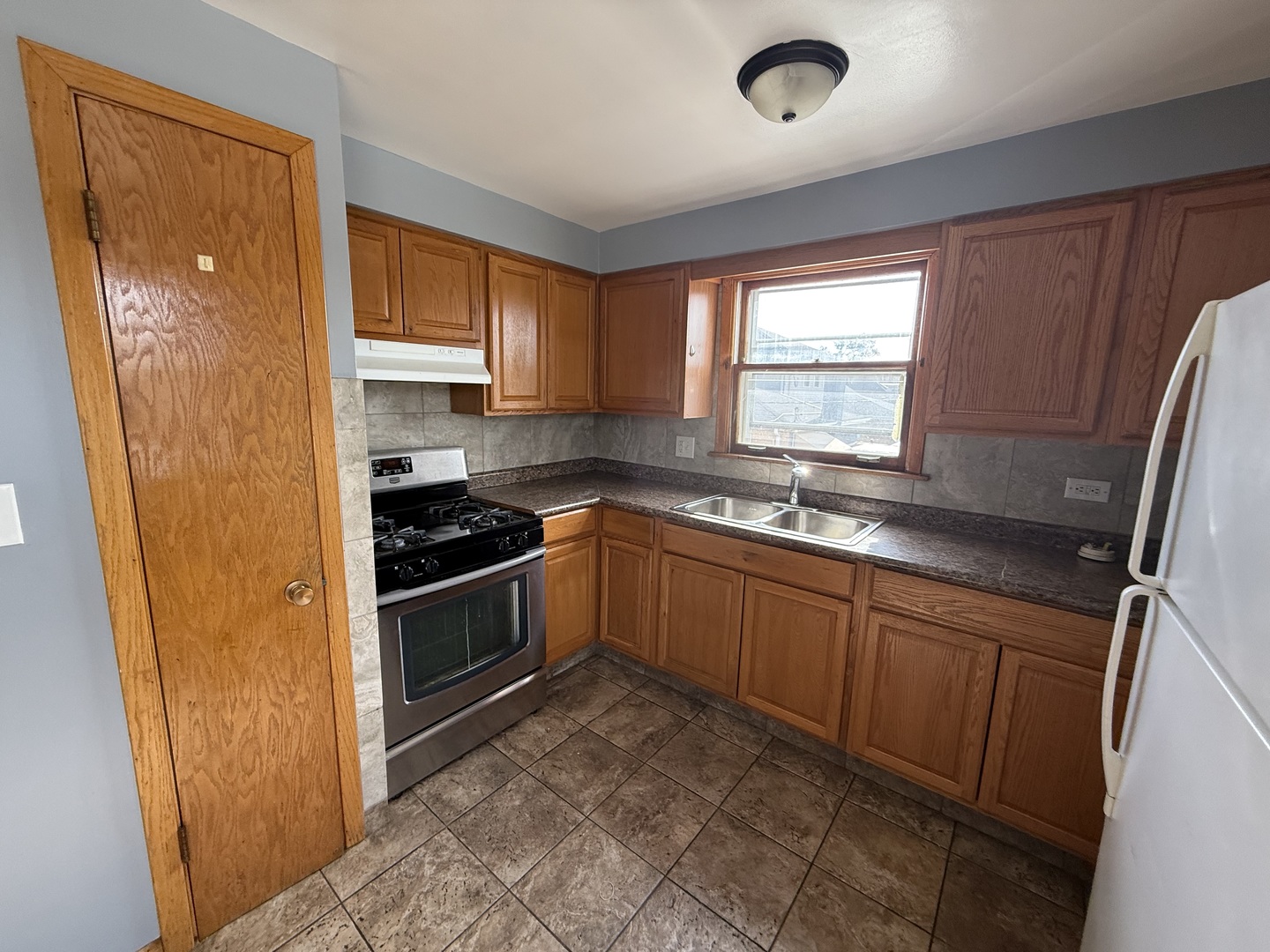 3556 North Nagle Avenue, Unit 2W Chicago, IL 60634 - Photo 5 of 14 a kitchen with stainless steel appliances granite countertop a stove a sink and a refrigerator