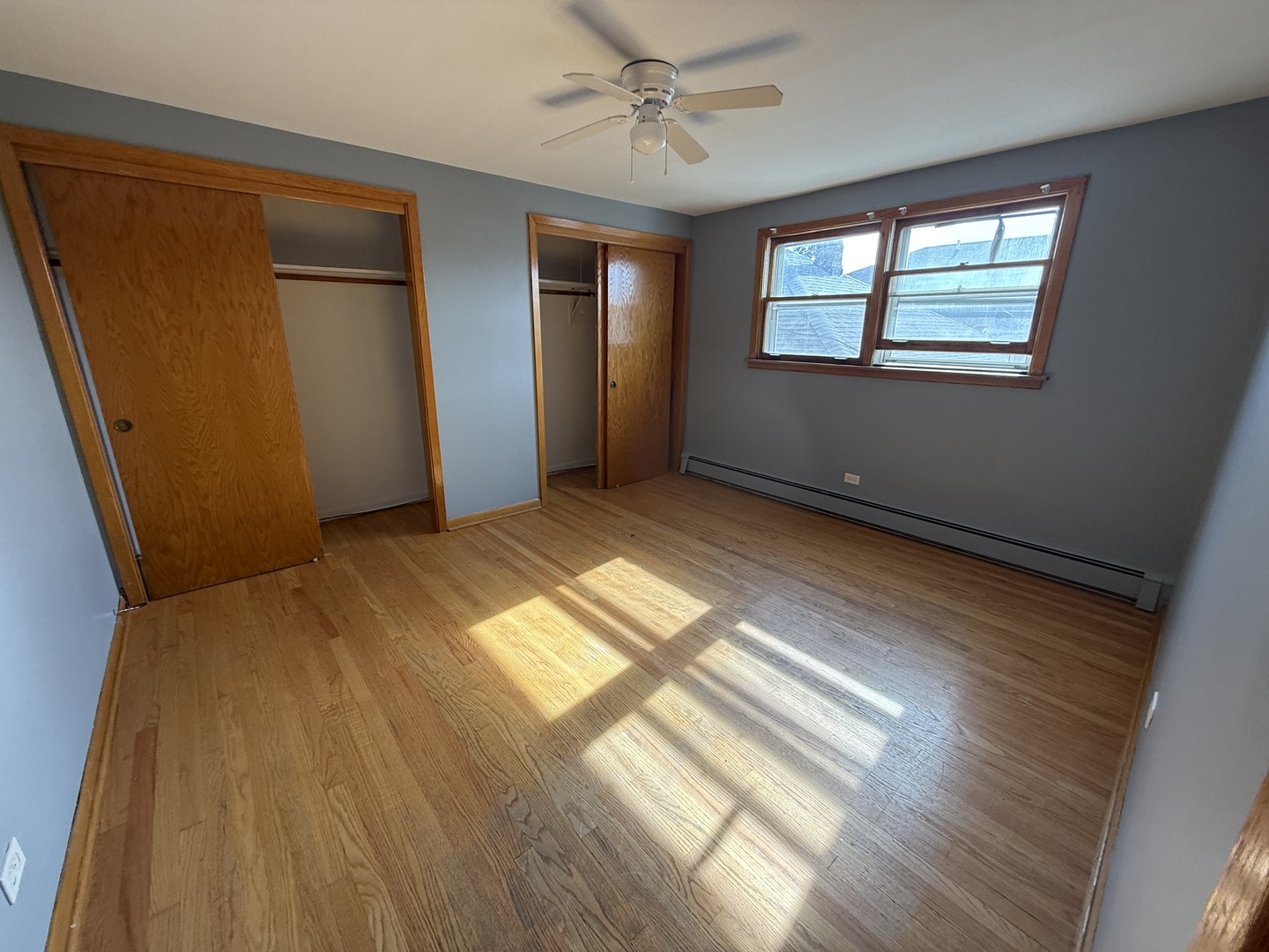 3556 North Nagle Avenue, Unit 2W Chicago, IL 60634 - Photo 10 of 14 a view of an empty room with wooden floor and windows