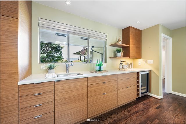 a bathroom with a double vanity sink and mirror with bathtub