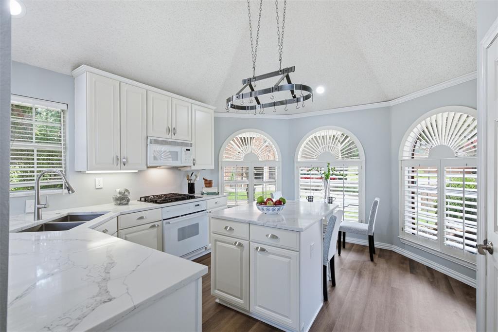14584 Blueberry Court Addison, TX 75001 - Photo 15 of 40 a kitchen with cabinets a window and appliances