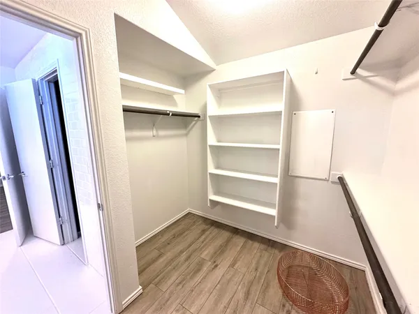 a view of walk in closet with empty racks