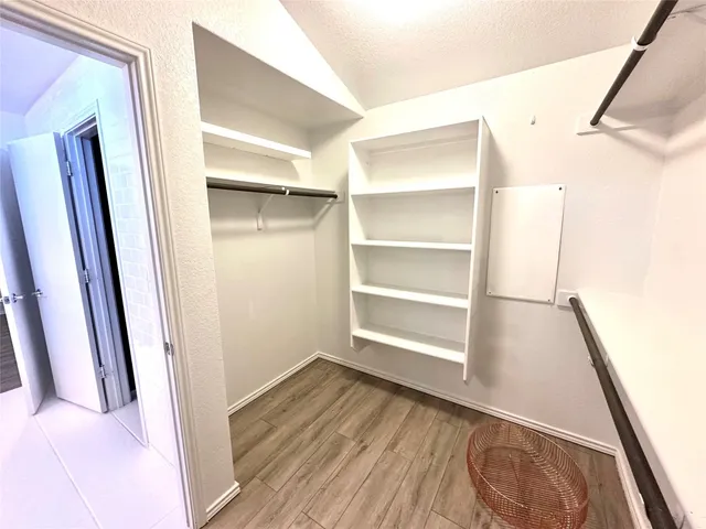 a view of walk in closet with empty racks