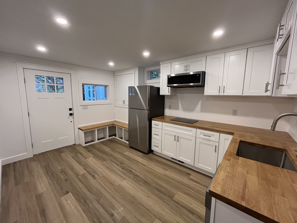 76 Sippewissett Road Falmouth, MA 02540 - Photo 19 of 28 a kitchen with stainless steel appliances granite countertop a refrigerator sink and cabinets