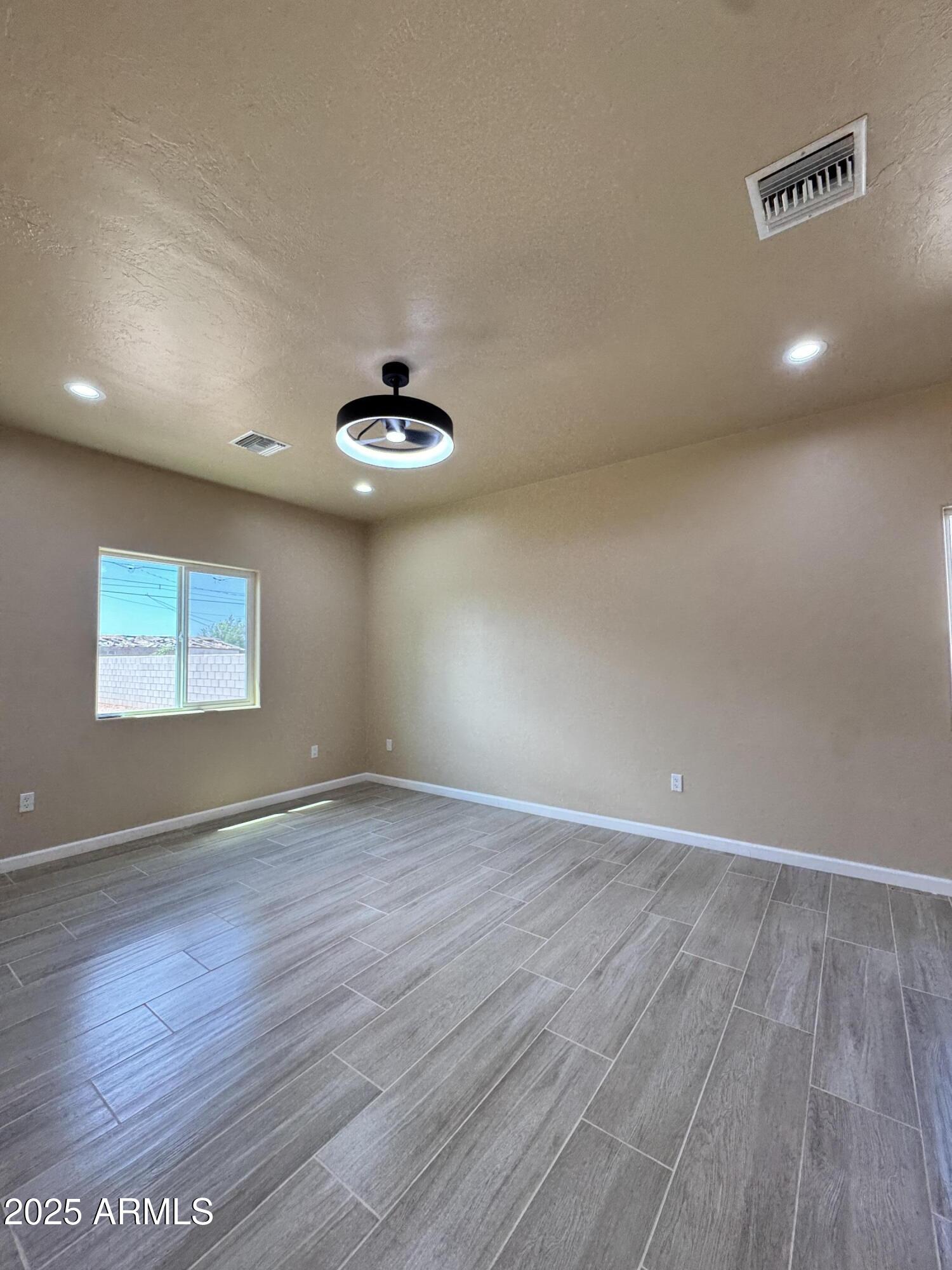 1457 East 23rd Street Douglas, AZ 85607 - Photo 14 of 23 an empty room with wooden floor and windows