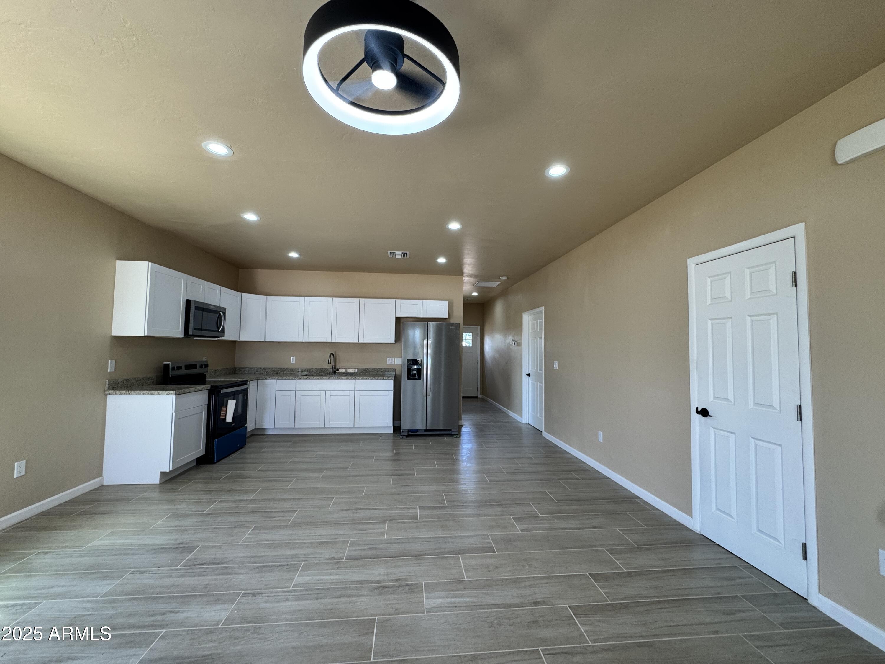1457 East 23rd Street Douglas, AZ 85607 - Photo 5 of 23 a open kitchen with kitchen island a stove and a wooden floors
