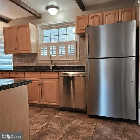 a kitchen with granite countertop a refrigerator and a sink