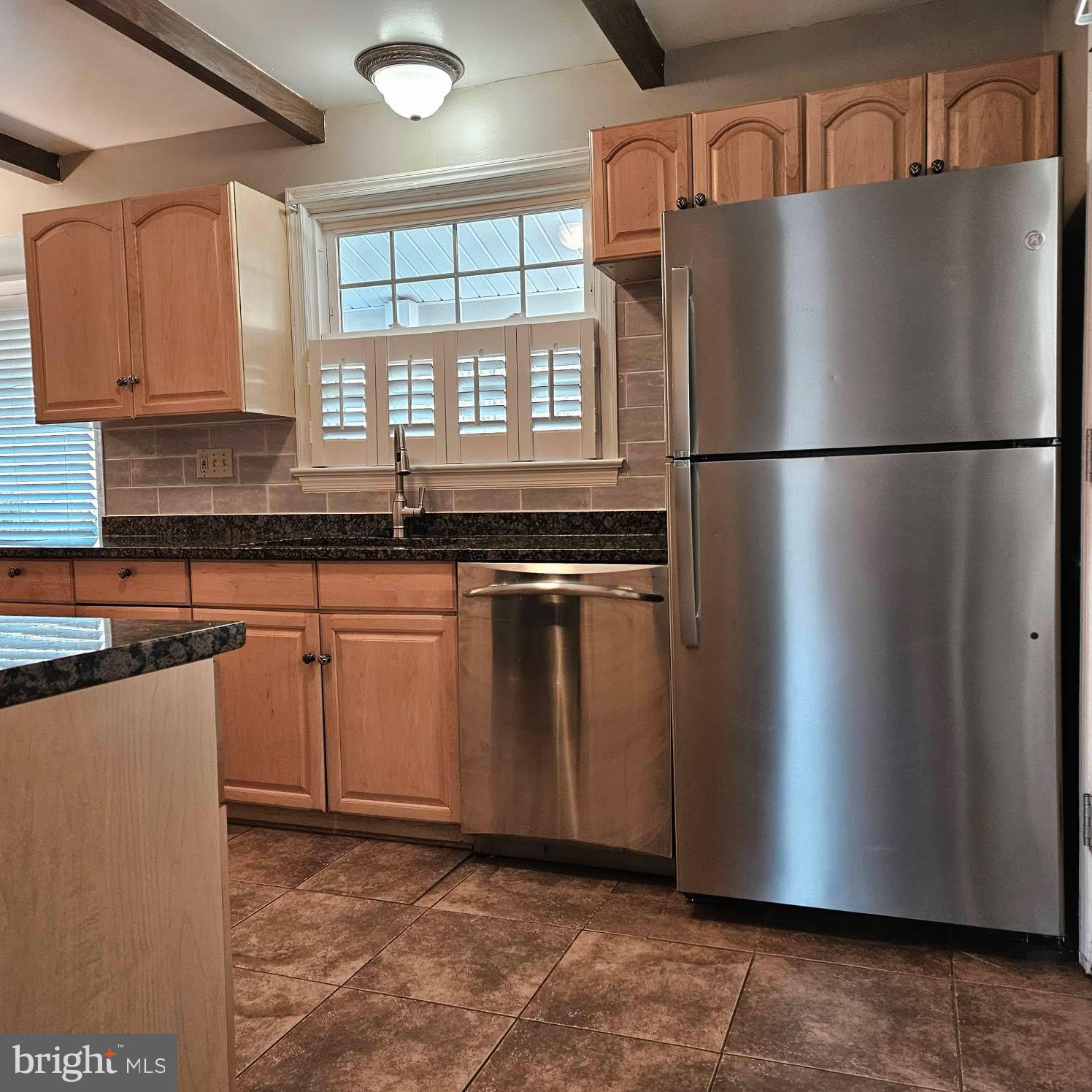 6602 Huntsman Boulevard Springfield, VA 22152 - Photo 4 of 14 a kitchen with granite countertop a refrigerator and a sink