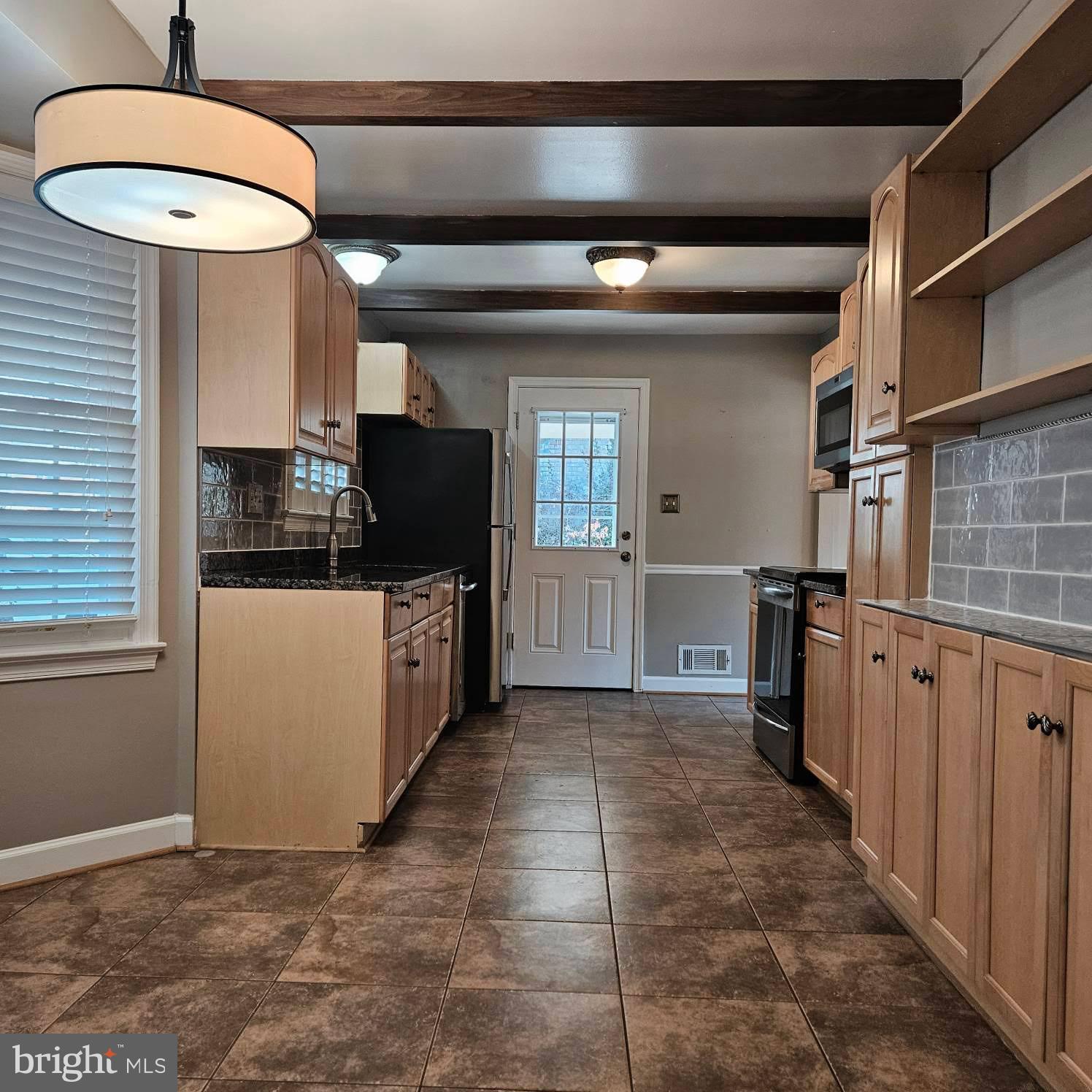 6602 Huntsman Boulevard Springfield, VA 22152 - Photo 5 of 14 a kitchen with stainless steel appliances a refrigerator and a stove top oven