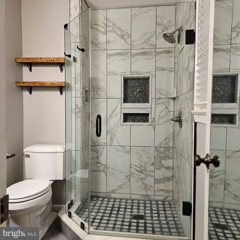 a bathroom with a toilet and a shower