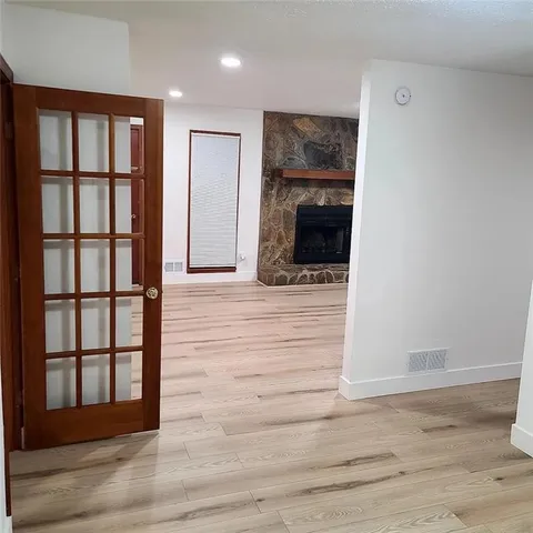 a view of a livingroom with wooden floor and a fireplace