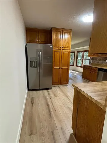 a view of a refrigerator in kitchen and wooden floor