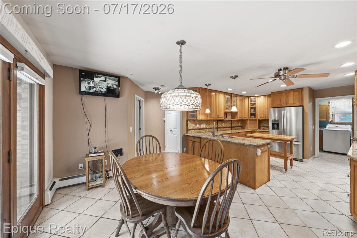 22520 Waltz Road New Boston, MI 48164 - Photo 24 of 43 Kitchen and dining area featuring light wood cabinetry, stainless steel appliances, a tiled backsplash, and granite countertops