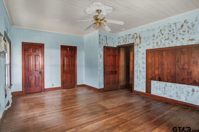 an empty room with window and a ceiling fan