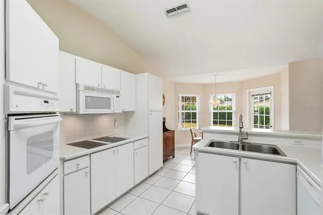 a kitchen with granite countertop a sink stove and refrigerator