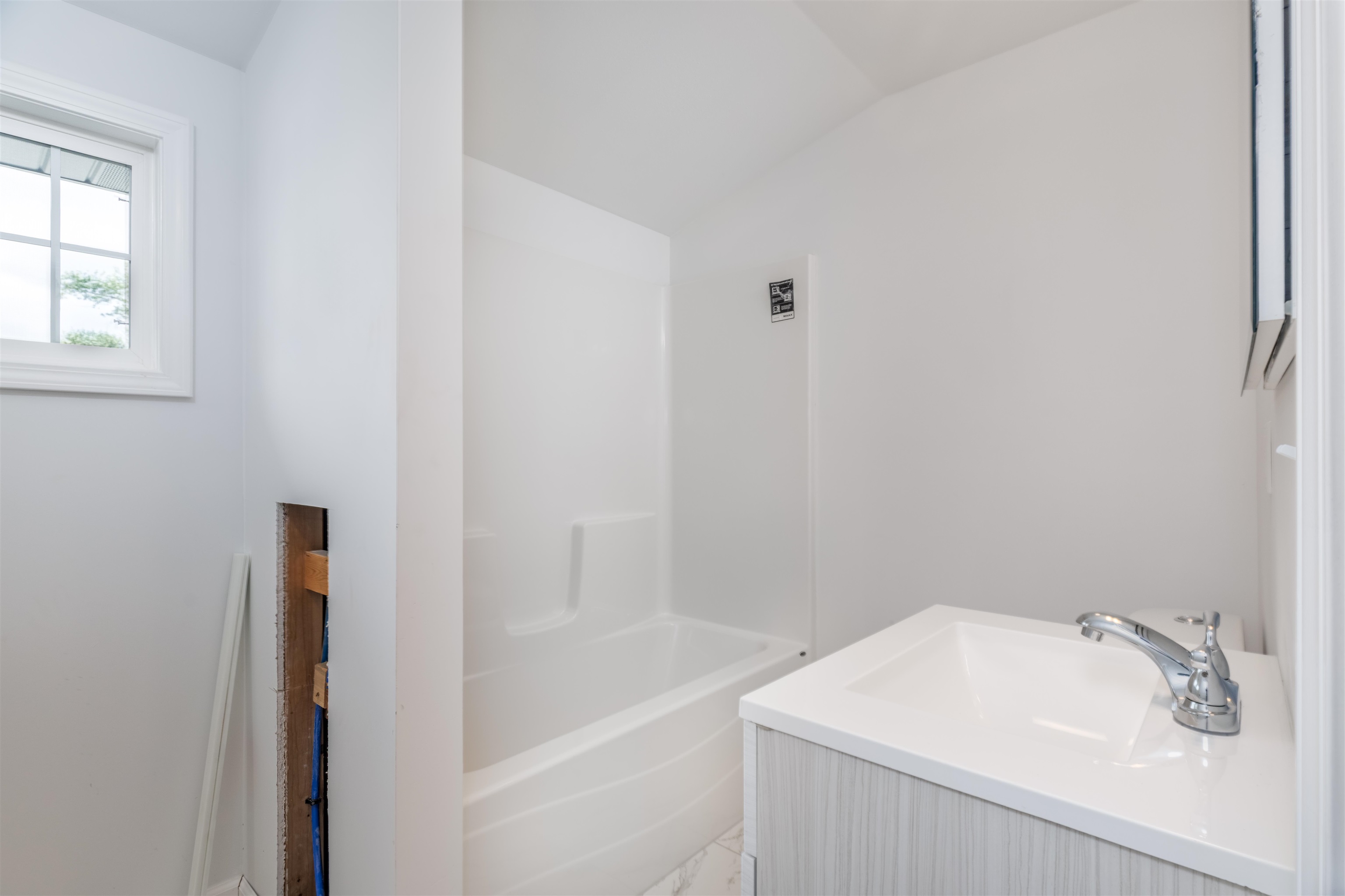 27 Astor Road Babbitt, MN 55706 - Photo 21 of 22 Upper level Full Bathroom featuring vanity, lofted ceiling, and shower / tub combination