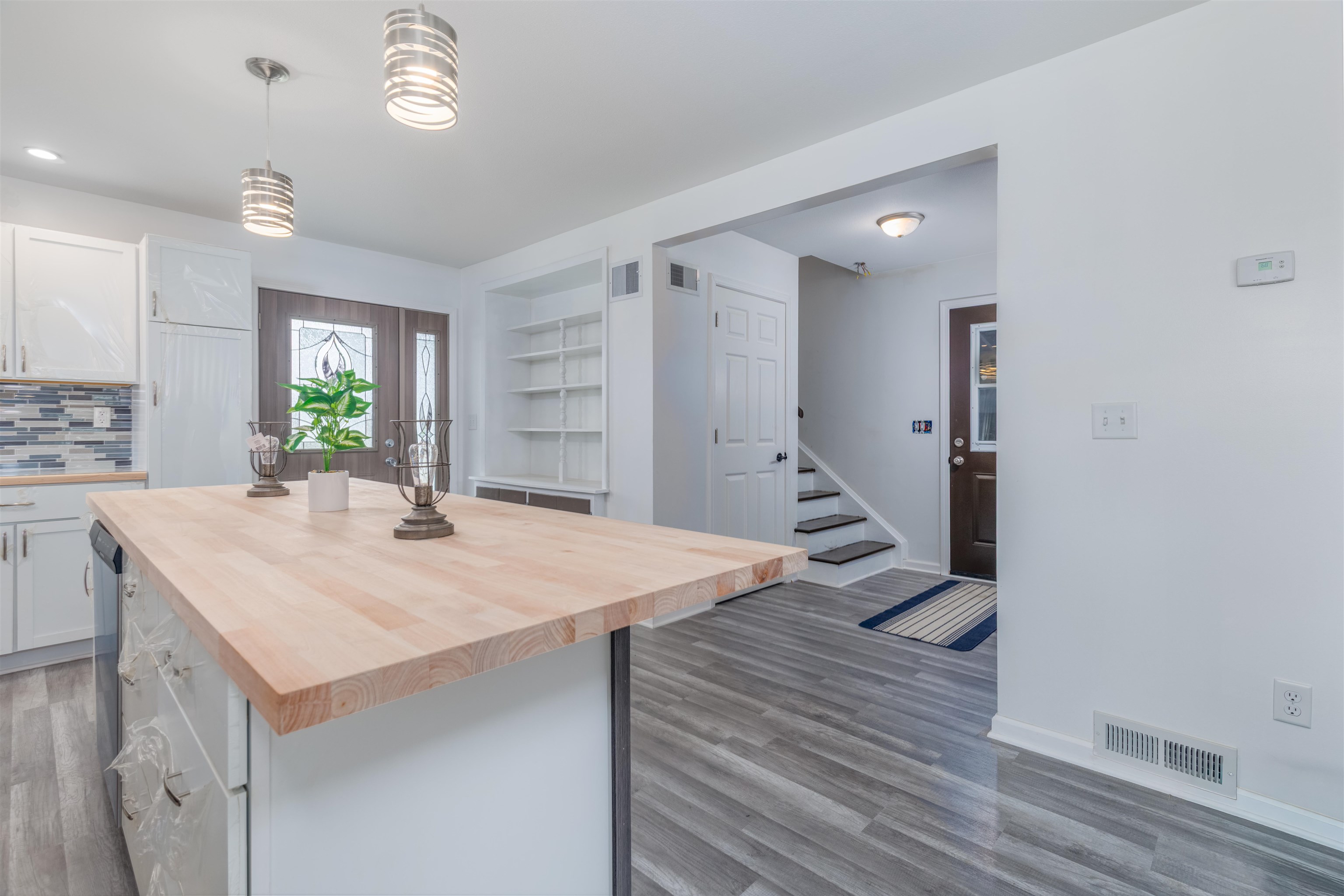 27 Astor Road Babbitt, MN 55706 - Photo 7 of 22 Kitchen with white cabinets, butcher block breakfast bar, built in features, and decorative light fixtures