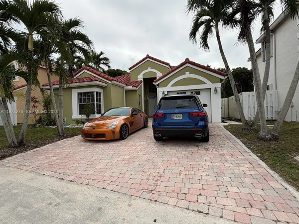a car parked in front of a house with a small yard