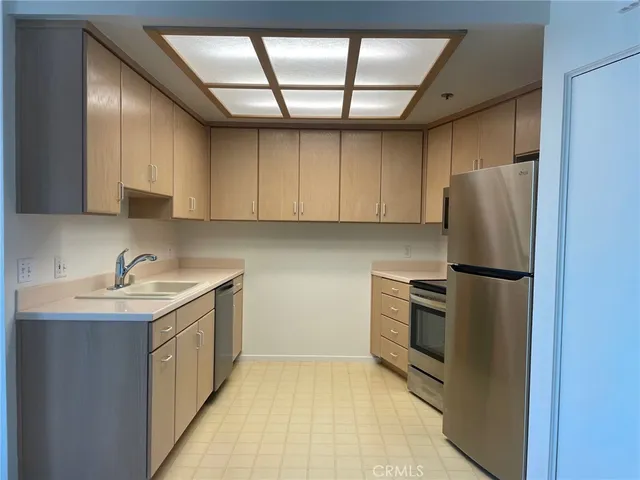 a kitchen with a refrigerator sink and cabinets