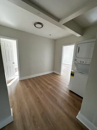 an empty room with wooden floor and white walls