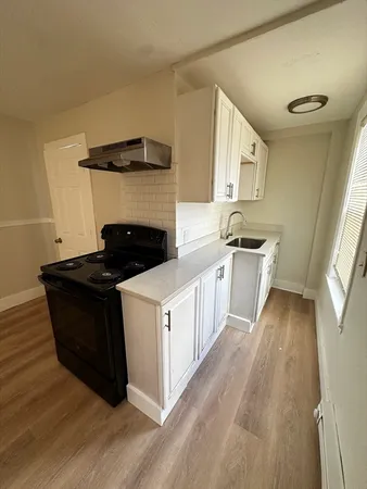 a kitchen with a cabinets and wooden floor