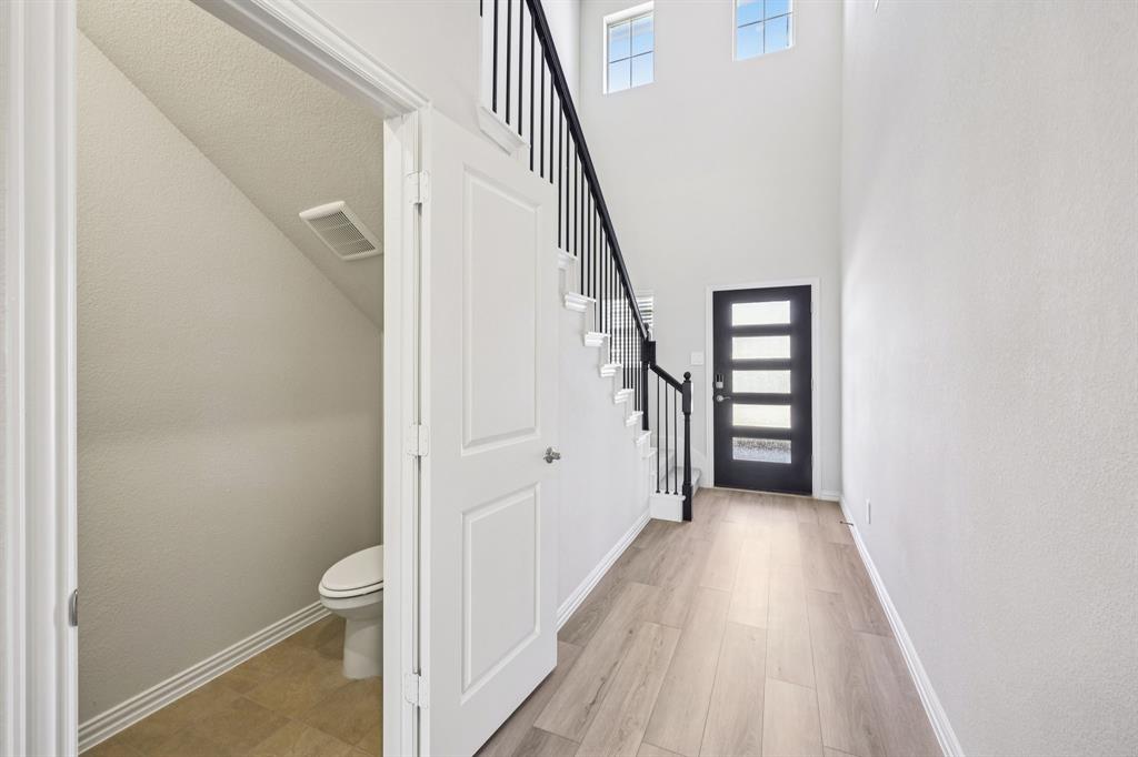 1737 Arches Road Anna, TX 75409 - Photo 8 of 38 a view of a hallway with wooden floor and staircase