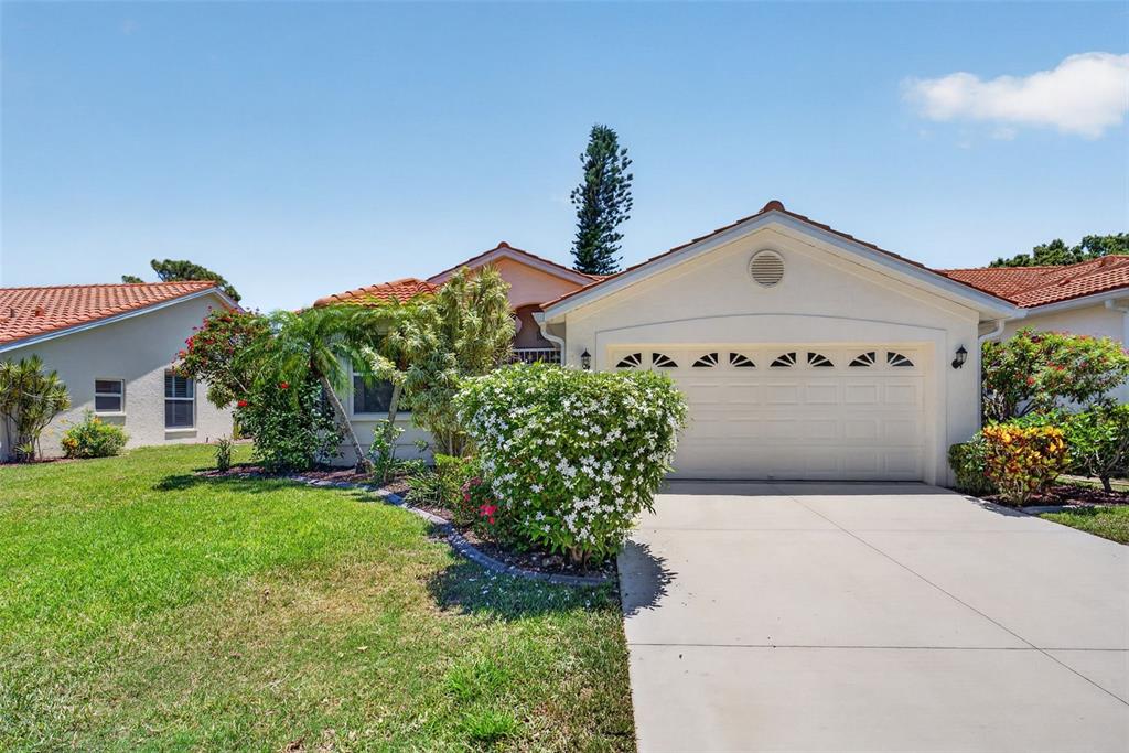 4266 Summertree Road Venice, FL 34293 - Photo 34 of 64 a front view of a house with a yard and garage