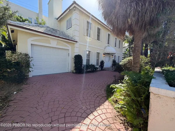 a view of a white house with a yard and plants