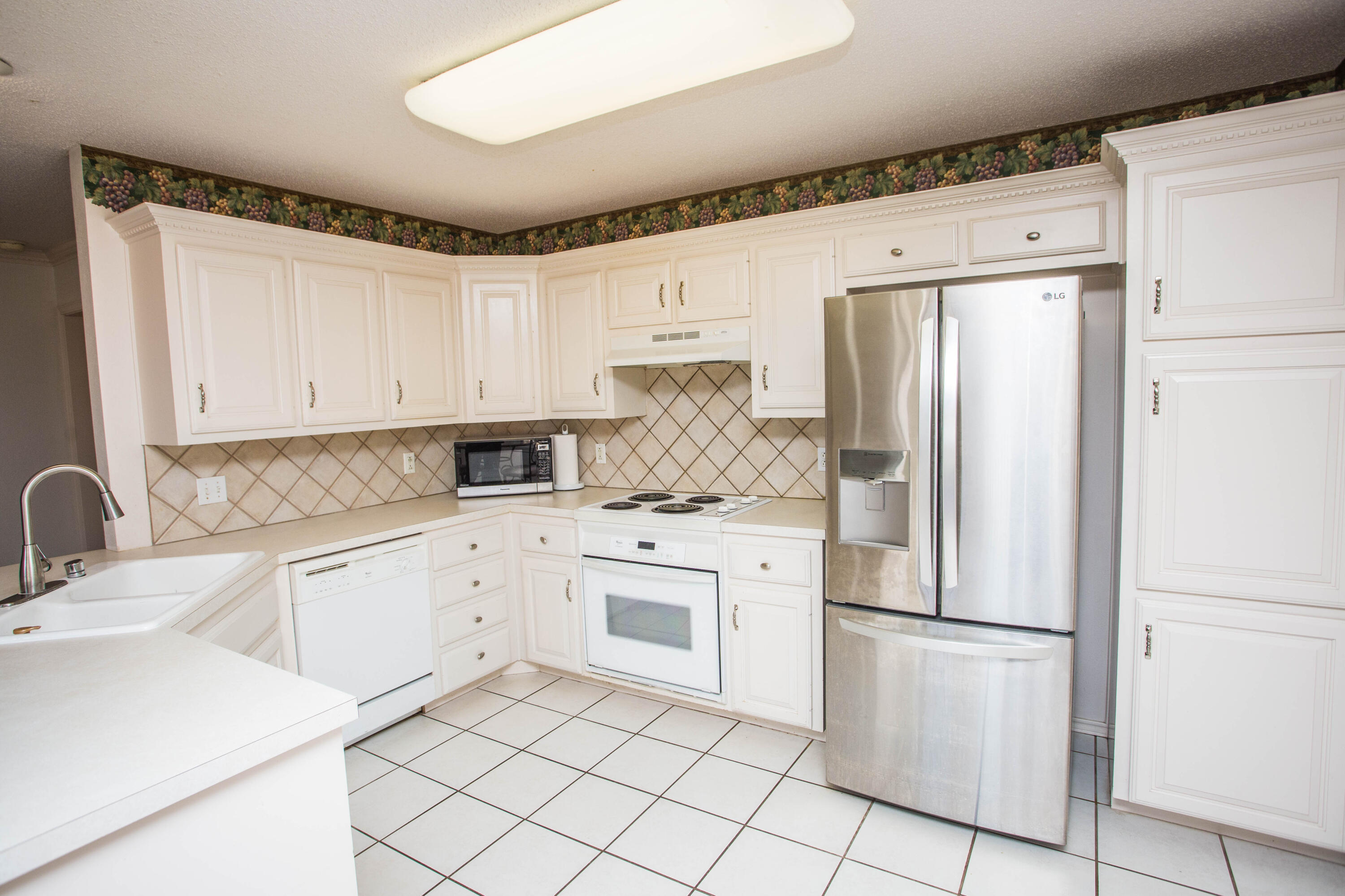 1904 76th Street Lubbock, TX 79423 - Photo 16 of 32 a kitchen with white cabinets white appliances and sink