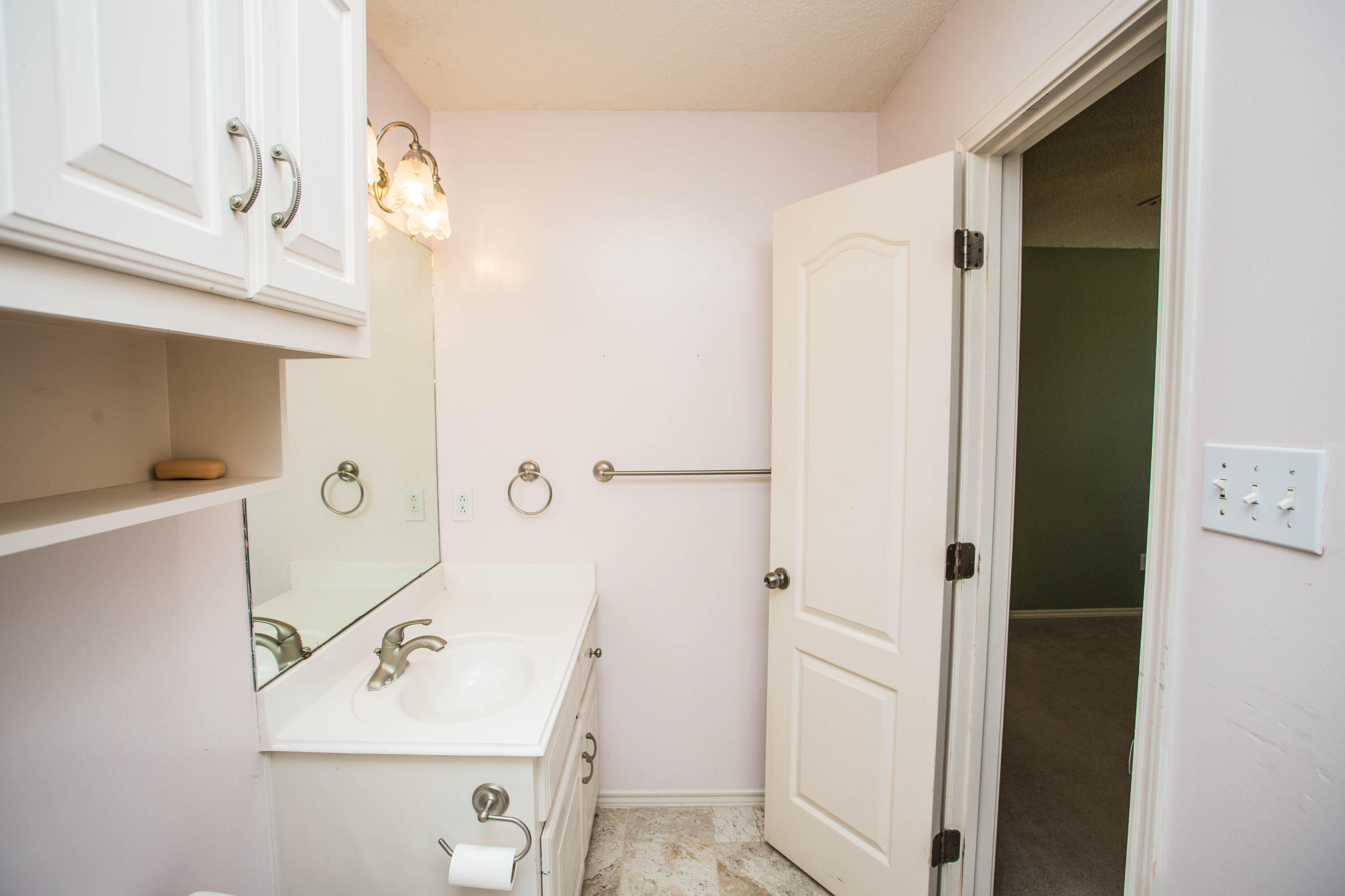 1904 76th Street Lubbock, TX 79423 - Photo 21 of 32 a bathroom with a sink and a mirror