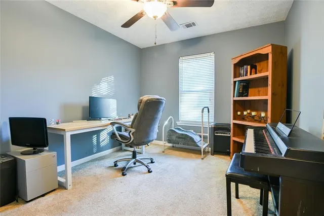 a view of a workspace with furniture and a window