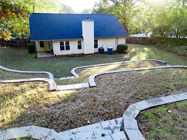 a view of a house with swimming pool and a yard