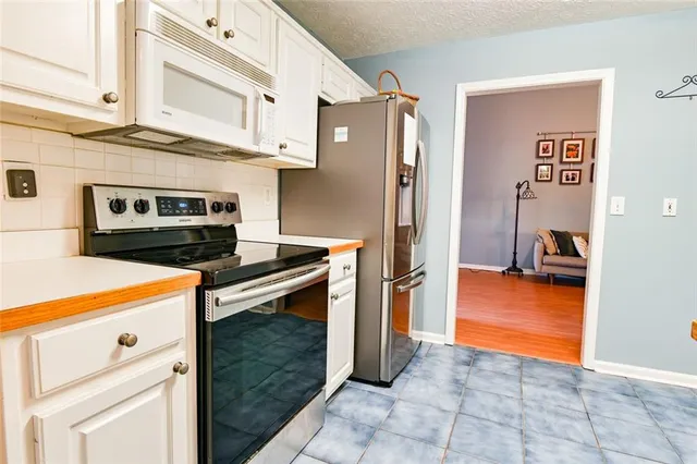 a kitchen with stainless steel appliances granite countertop a refrigerator and a stove
