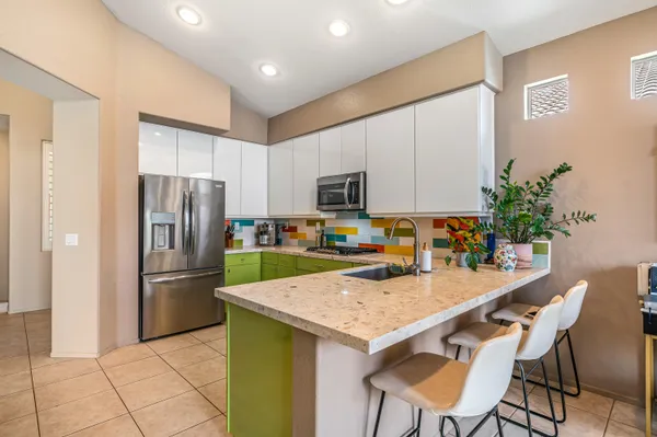 a kitchen with granite countertop a refrigerator and a stove top oven