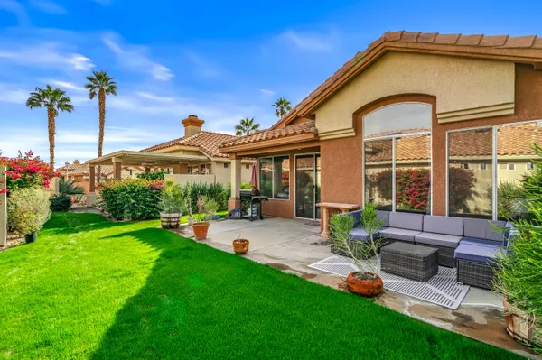 a view of a house with backyard sitting area and garden