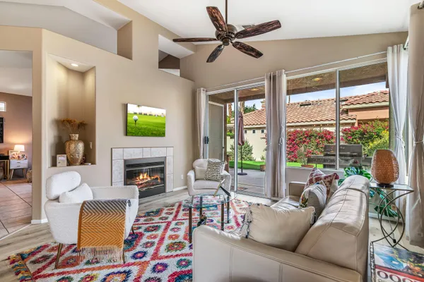 a living room with furniture fireplace and a large window
