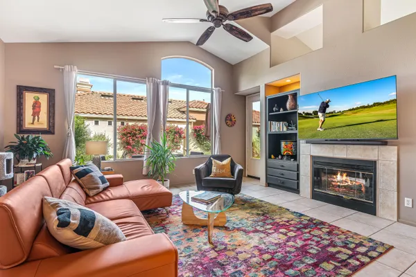 a living room with furniture a fireplace and a large window