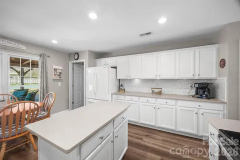 a kitchen with a sink a stove a refrigerator and white cabinets