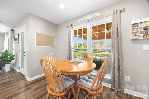 a dining room with furniture potted plants and wooden floor