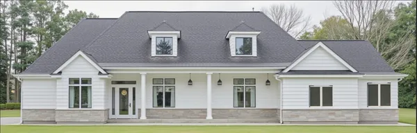 a view of a brick house with yard and large trees