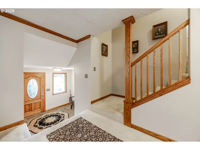 a view of a livingroom with wooden floor and stairs